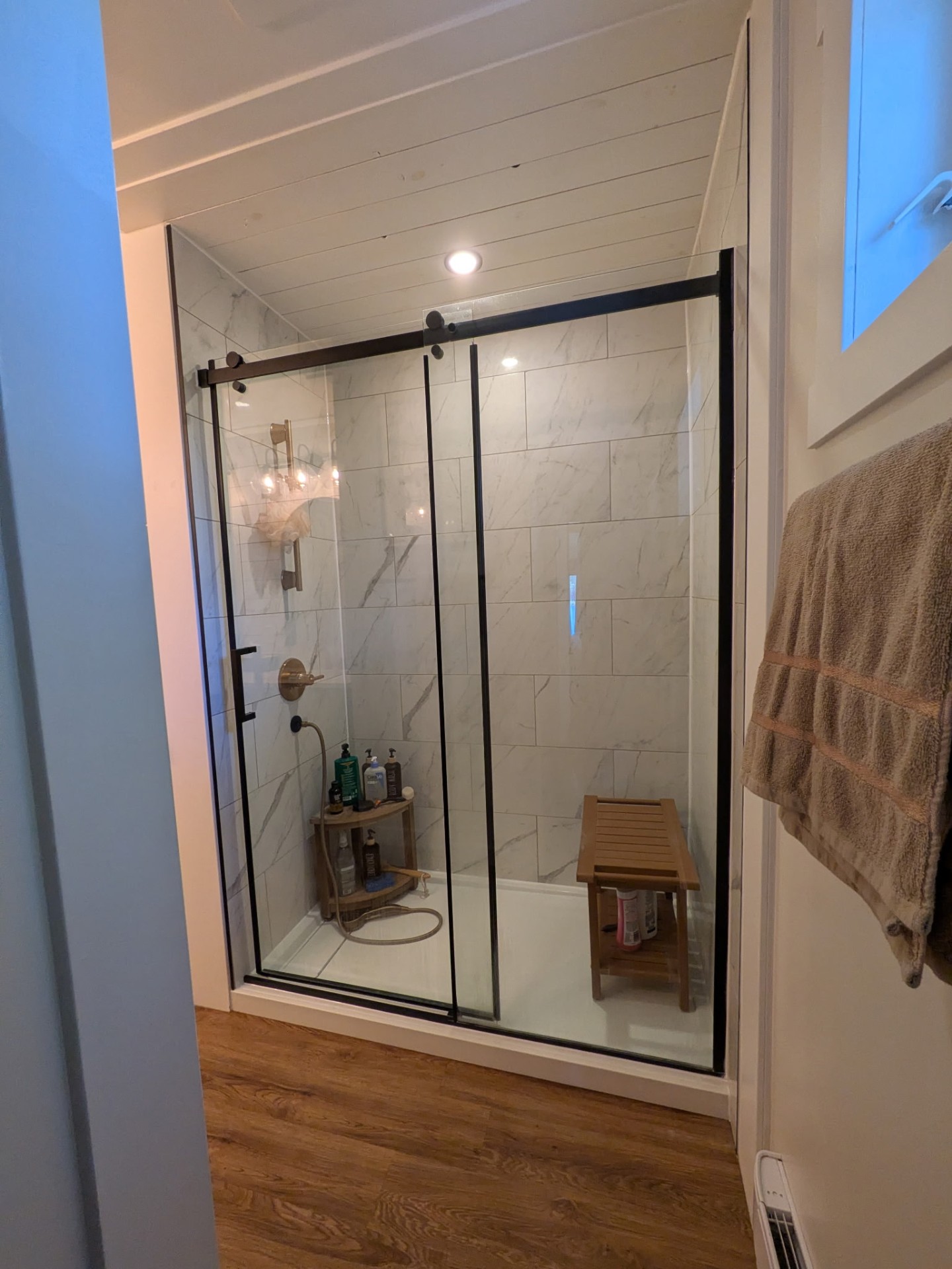 Tiled walk-in shower with glass sliding door